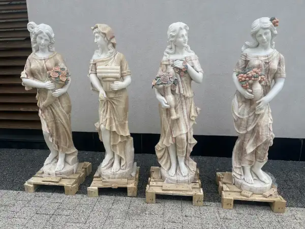 Cztery marmurowe rzeźby kobiet, ukazujące dynamikę i bogactwo zdobień, typowe dla cech rzeźby barokowej.