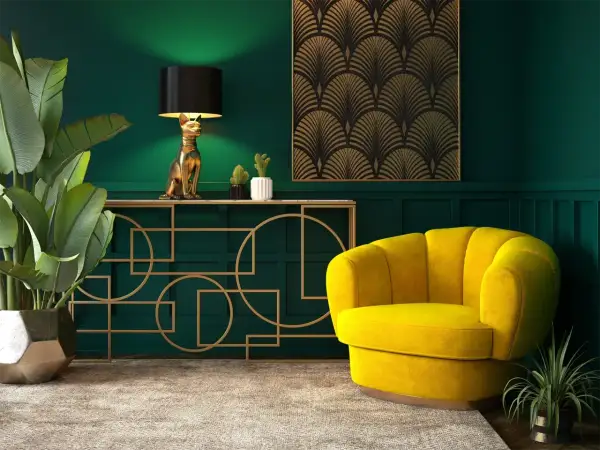 Elegancja w stylu sztuka art deco: złoty kot-lampa, żółty fotel i geometryczne zdobienia na tle butelkowej zieleni.