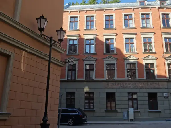 Urokliwe kamienice Gdańska z latarniami ulicznymi i ceglaną fasadą.