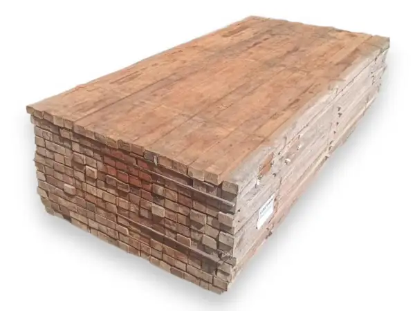 Pila de tablones de madera, mostrando la textura y el color rojizo característico de que es la madera tropical, lista para construcción.