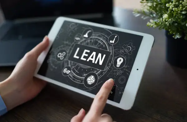 Tablet z ekranem prezentującym koncepcję lean management. Ikony symbolizują procesy, innowacje i optymalizację.