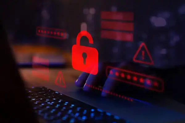 Czerwona kłódka i ostrzeżenia na ekranie laptopa symbolizują zagrożenie. Uważaj na spear phishing, który może prowadzić do wycieku danych.