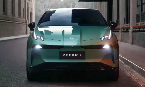 El elegante Zeekr X verde se detiene en una calle urbana, sus luces LED brillan intensamente.
