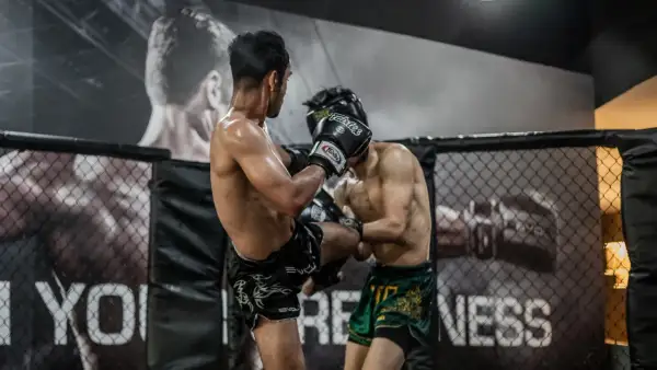 Two fighters in a ring. One lands a kick, likely feeling what does it feel like to get hit in the liver.