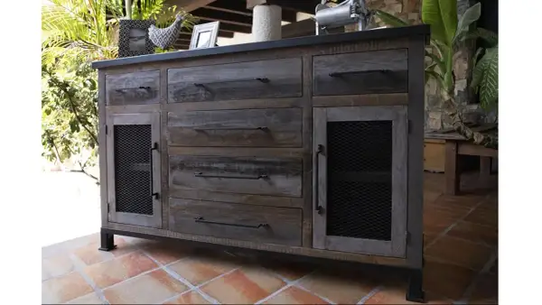 Buffet en bois vieilli, prêt à se relooker. Ses tiroirs et portes grillagées lui donnent un style industriel unique.