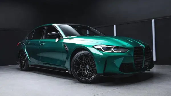 Błyszczący, sportowy sedan w kolorze midnight green, z czarnymi felgami i agresywnym przodem, gotowy na nocne wyścigi.