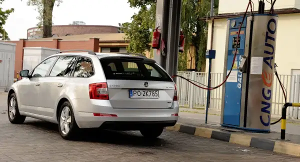 Srebrne kombi Skoda Octavia tankuje gaz LPG propan-butan na stacji paliw.