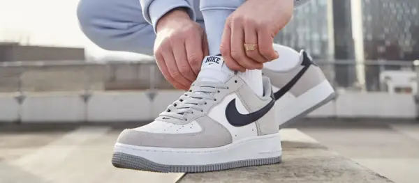 Mani che allacciano le Nike Air Force 1, un classico intramontabile, ricordando quando sono uscite le Air Force 1.
