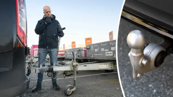 Man kontrollerar kopplingen till en släpvagn, kanske för att säkerställa att fordons totalvikt inte överskrids.