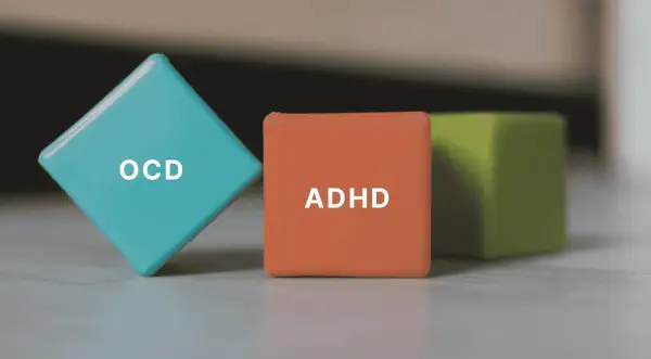 Tre färgglada kuber med texten "OCD" och "ADHD" på. Kanske en metafor för hur en person med OCD kan uppleva sina tankar.