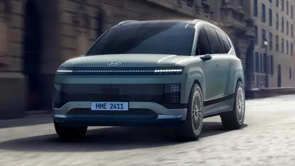Przyszłościowy Hyundai Ioniq 9 w kolorze miętowym, poruszający się po miejskiej ulicy.