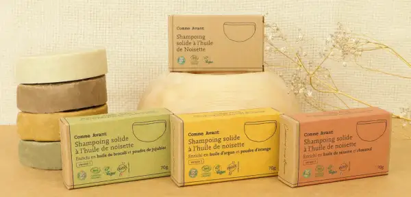 Pile de savons solides et boîtes de shampoing solide Comme Avant. Choix écologique entre shampoing solide ou liquide.