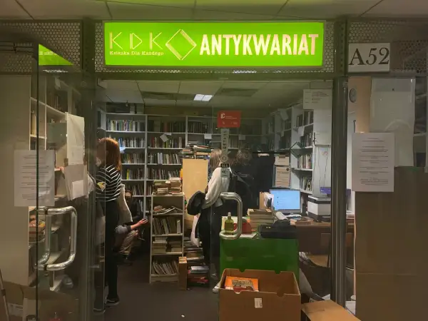 W antykwariacie "Książka Dla Każdego" panuje atmosfera cmentarz zapomnianych książek. Wnętrze pełne regałów z literaturą, gdzie ludzie przeglądają stare tomy.