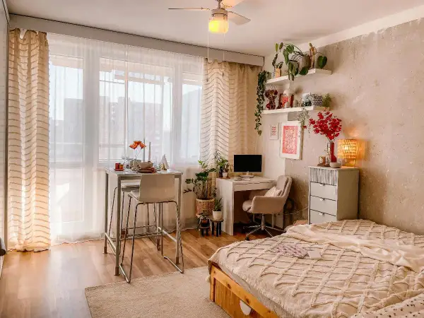 Idee per arredare una casa piccola: un angolo studio, un tavolo alto per mangiare e un letto accogliente, tutto in uno spazio compatto.