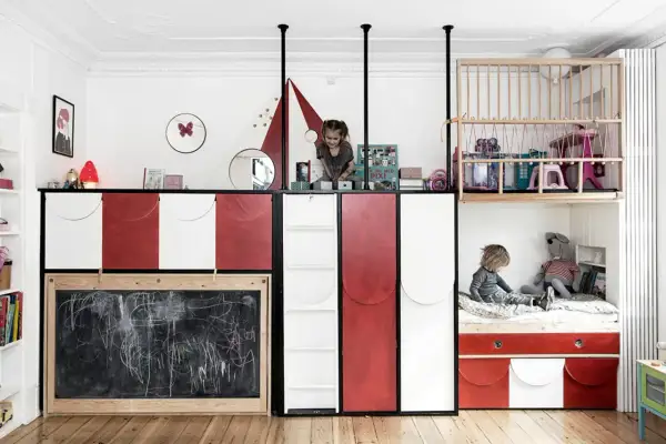 Zwei Kinder teilen sich ein kreatives Zimmer mit Hochbetten und Tafel.