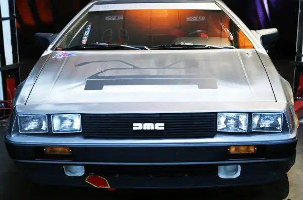 Przód kultowego DeLorean z charakterystycznym logo DMC na grillu.