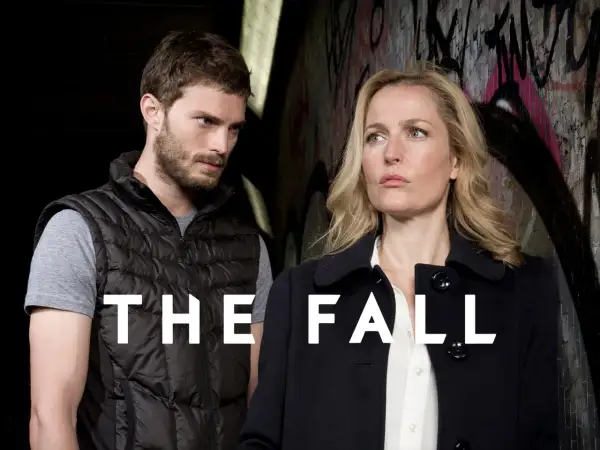 En man och en kvinna står framför en graffiti-klädd vägg. Texten "THE FALL" syns tydligt.