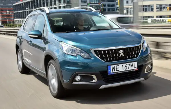 Turkusowy Peugeot 2008 na drodze. Kierowca w środku. Wiele pozytywnych peugeot 2008 opinie o tym modelu.