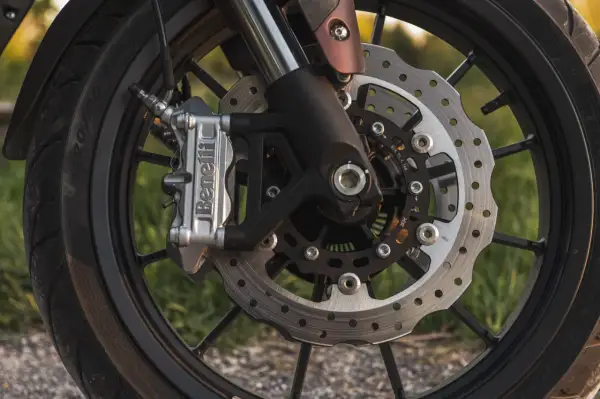 Zbliżenie na tarczę hamulcową motocykla z zaciskiem Benelli.