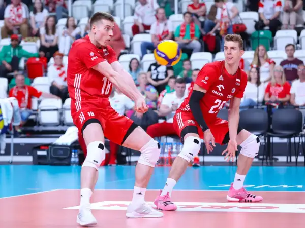 Dwóch siatkarzy w czerwonych strojach walczy o piłkę. Jeden z nich, numer 16, przyjmuje zagrywkę, drugi, numer 25, czeka na dalszy rozwój akcji. Zielona kartka w siatkówce nie istnieje, ale ta akcja jest warta złota!