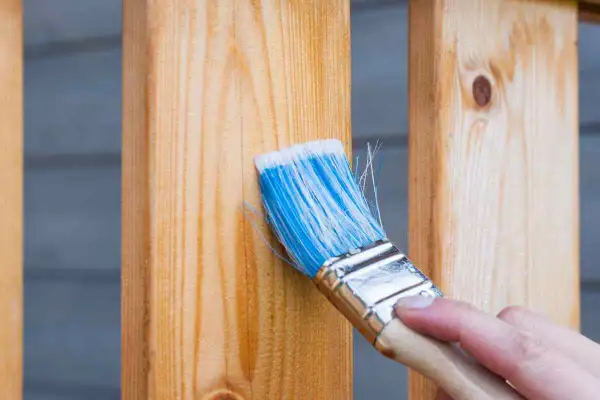 Pennello blu applica una finitura trasparente per riportare il legno al naturale, esaltandone le venature.
