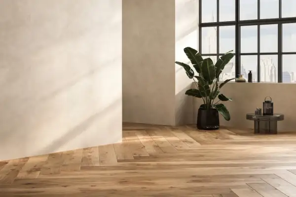 Sol en carrelage imitation parquet, aspect bois naturel. Un inconvénient potentiel : l'entretien des joints. Une plante verte et une vue urbaine.