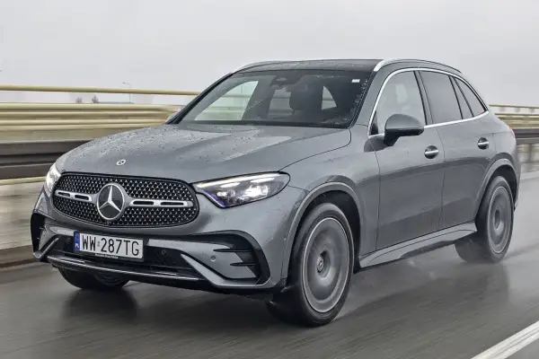 Szary Mercedes-Benz GLC jedzie po mokrej drodze.