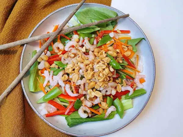 En fräsch asiatisk nudelsallad med räkor, grönsaker och jordnötter. Perfekt för en lätt lunch eller middag.