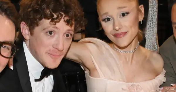Ariana Grande z partnerem Ethanem Slaterem, uśmiechnięci, w eleganckich strojach.