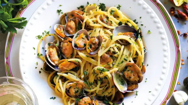 Spaghetti alle vongole cremosi come al ristorante, un piatto invitante con pasta, vongole e prezzemolo fresco.