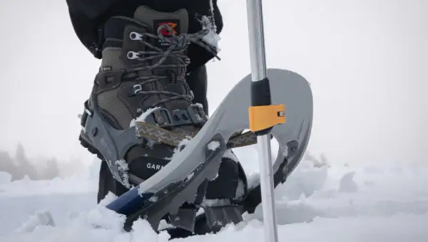 Scarponi e racchette da neve: scopri cosa sono le ciaspole per camminare sulla neve fresca, con un bastone da trekking.