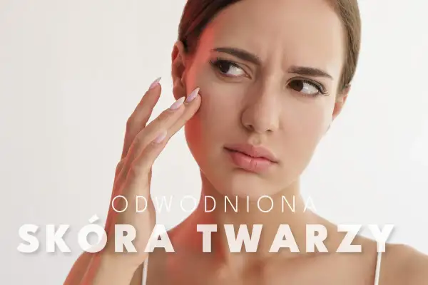 Kobieta zmartwiona stanem swojej odwodnionej skóry twarzy, dotyka policzka.