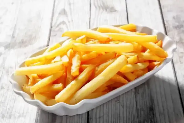 Złociste frytki w białej miseczce, wyglądają jak te z McDonald's. Chcesz wiedzieć jak zrobić frytki z McDonald's?