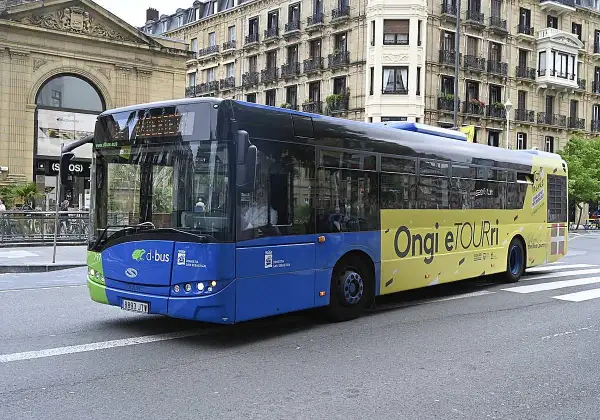 Autobús azul y amarillo de Dbus en Ondarroa, San Sebastián, con el lema "Ongi etorri".
