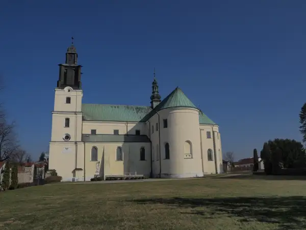 Bazylika w Gidlach z charakterystyczną wieżą i zielonym dachem, na tle błękitnego nieba.
