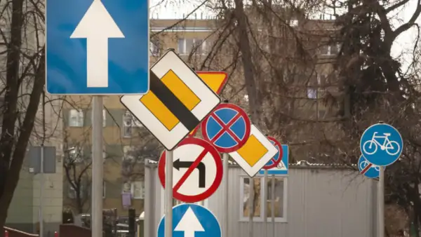 Mnóstwo znaków drogowych, jakby test na prawo jazdy. Strzałka do przodu, zakaz skrętu, pierwszeństwo, rowerzyści i postój.
