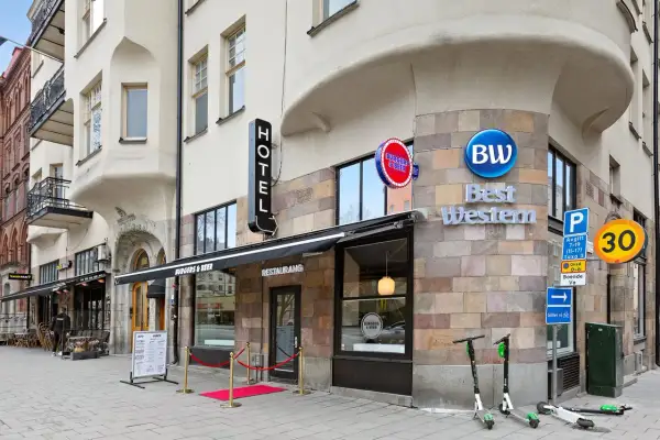Best Western hotel vid 108, med restaurang Burgers & Beer och en taco bar. Elsparkcyklar står parkerade utanför.