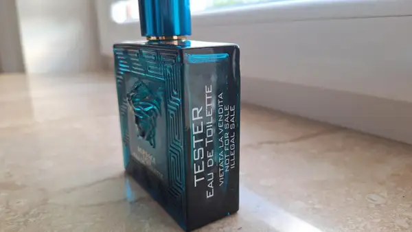 Niebieska butelka testera Versace Eros Eau de Toilette z greckim wzorem i Meduzą.