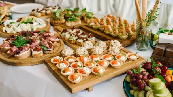 Vielfältige Snacks zum Aperitif: Bruschetta mit Salami, Käseplatte, Garnelen-Häppchen und süße Törtchen mit Kaviar.