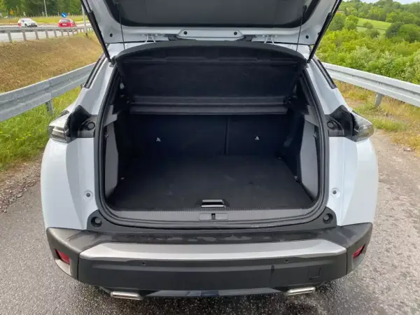 Otwarty bagażnik białego Peugeot 2008. Wymiary tego SUV-a pozwalają na wygodne pakowanie.