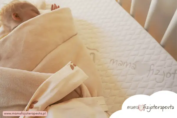 Niemowlę śpi na materacu z napisem "mama fizjoterapeuta". Jaki materac dla niemowlaka fizjoterapeuta poleca?