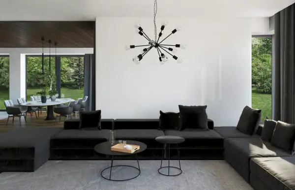 Nowoczesny salon z czarną sofą i designerskim oświetleniem. Sufit z belkami dodaje charakteru.