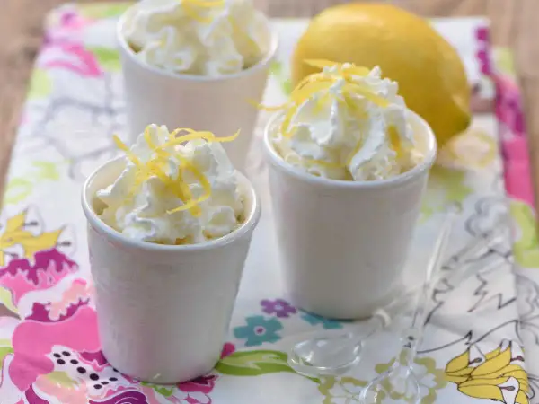 Délicieuse mousse ricotta citron, garnie de zestes frais et servie dans de petits ramequins blancs. Un dessert léger et rafraîchissant.