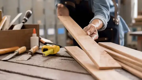 Manos expertas preparan madera para restaurar. Aprende como quitar pintura de la madera sin dañarla con estas herramientas.
