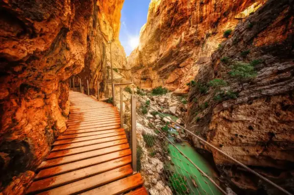 Chemin de bois longeant une gorge spectaculaire en Espagne, avec une rivière émeraude en contrebas. Un trek inoubliable.