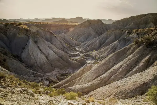 Paisaje erosionado en el desierto de Tabernas que ver. Barrancos y montañas de tierra arcillosa bajo un cielo claro.