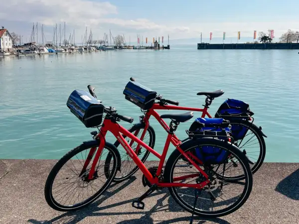 Zwei rote Fahrräder stehen am Ufer des Bodensees in Friedrichshafen, bereit für eine Tour.