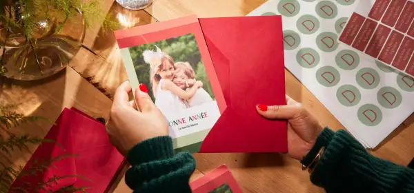 Préparation de textes de noël familial : une carte avec deux enfants souriants et des enveloppes rouges.