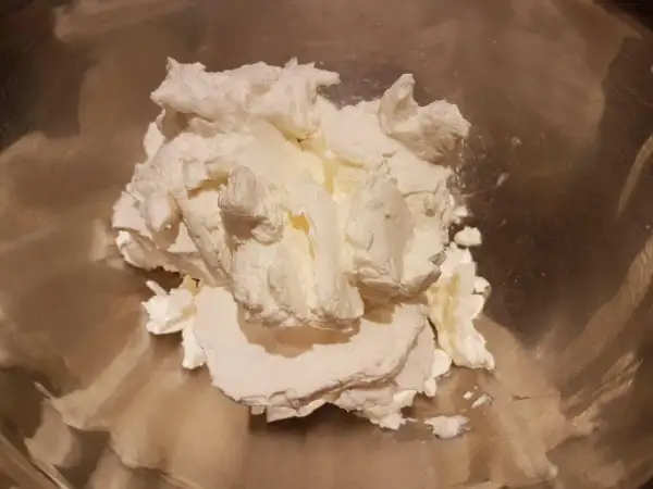Krem z mascarpone w metalowej misce, gotowy do ubijania.