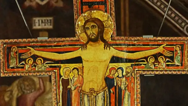 Stary krzyż franciszkański z malowanymi postaciami Jezusa, aniołów i świętych.